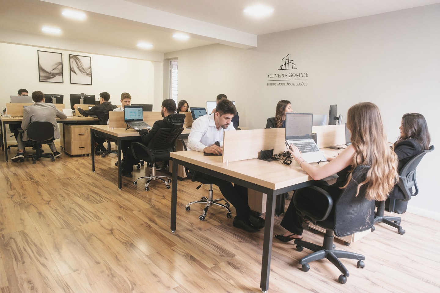 Modern open-plan office with employees working at individual workstations
