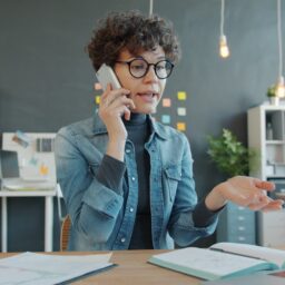 Woman talking on phone at desk in office