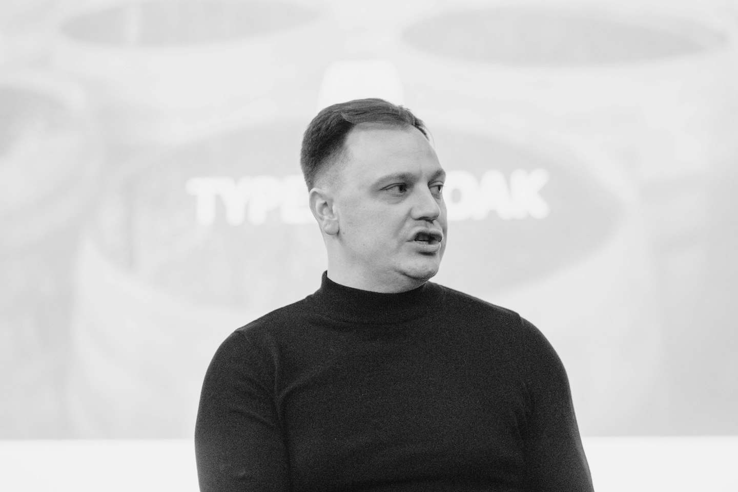 a man standing in front of a projection screen