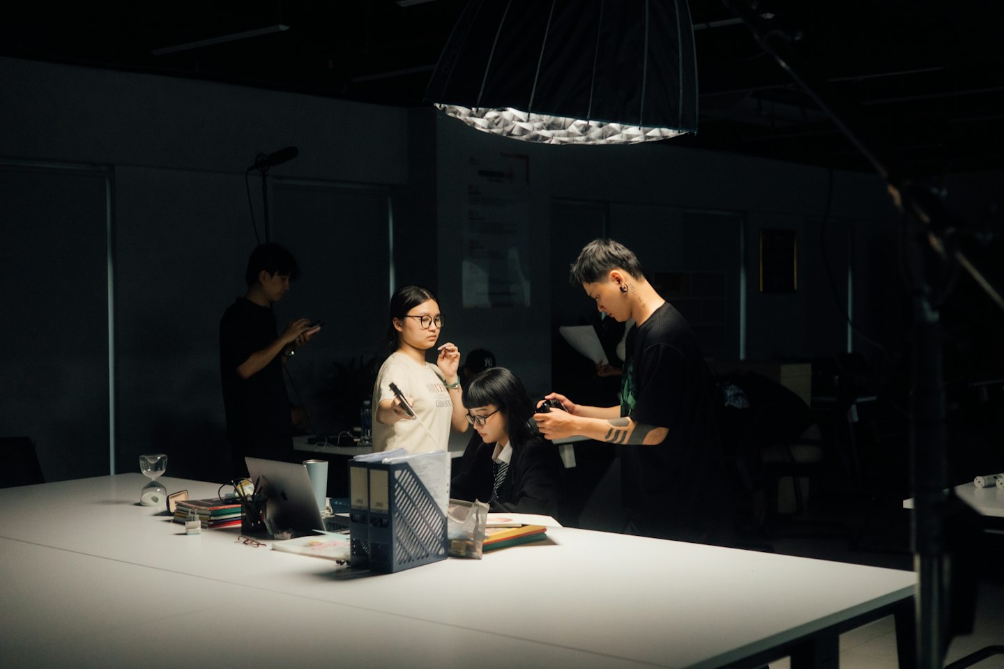 A crew prepares for a shoot in a dimly lit room