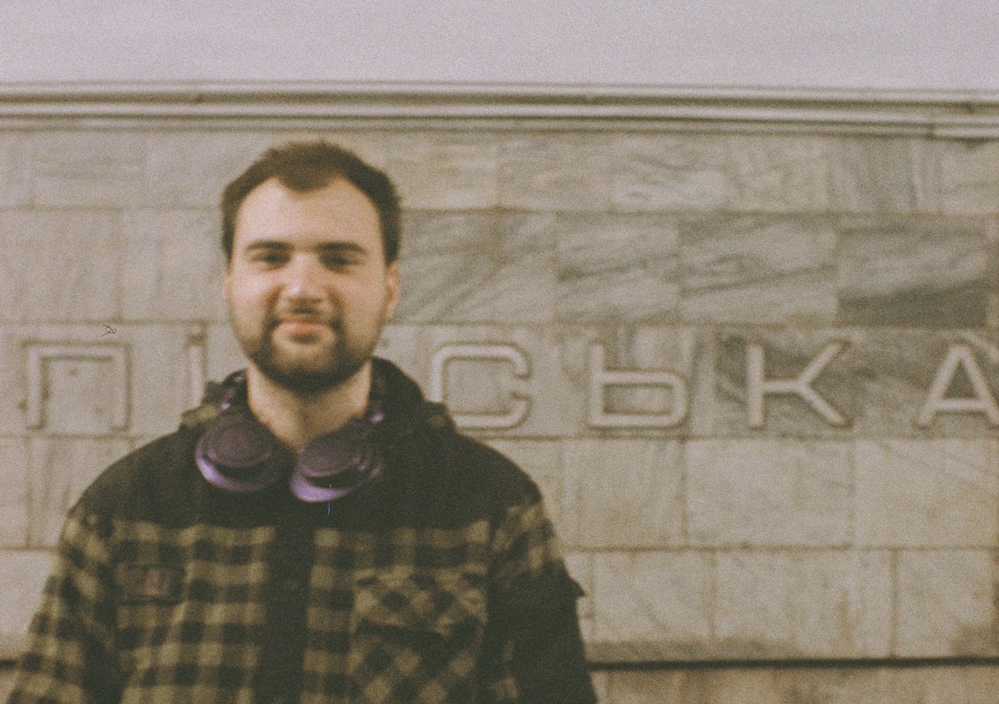 Man in plaid jacket with headphones around neck